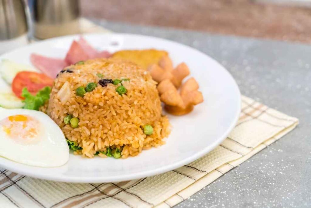Dish with a cup of ham and pineapple fried rice