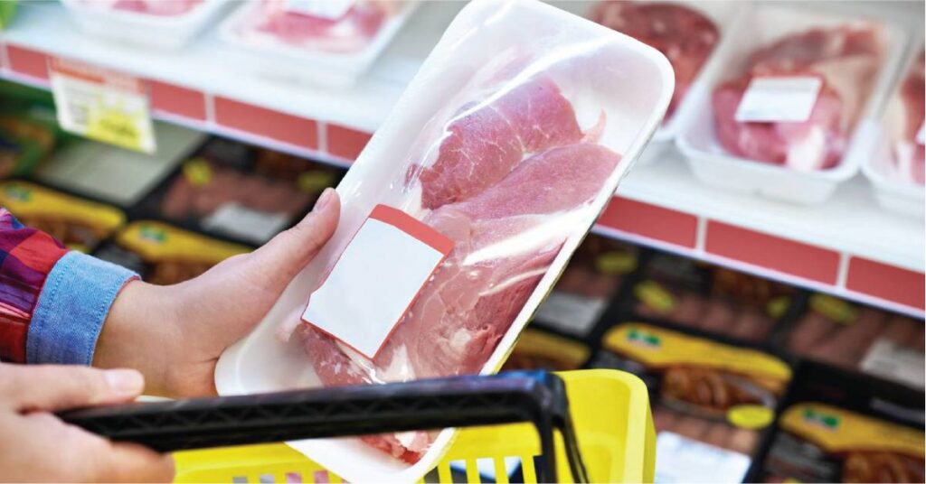 A customer inspecting a packaged meat on a grocery store